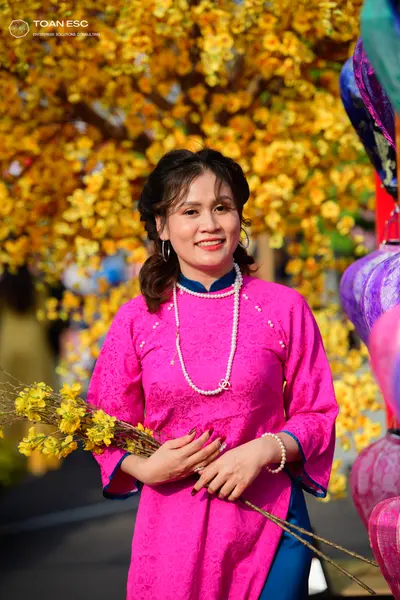 Dancesport competitor: Female dancer: bright pink long-sleeved patterned tunic with dark blue pants/ski