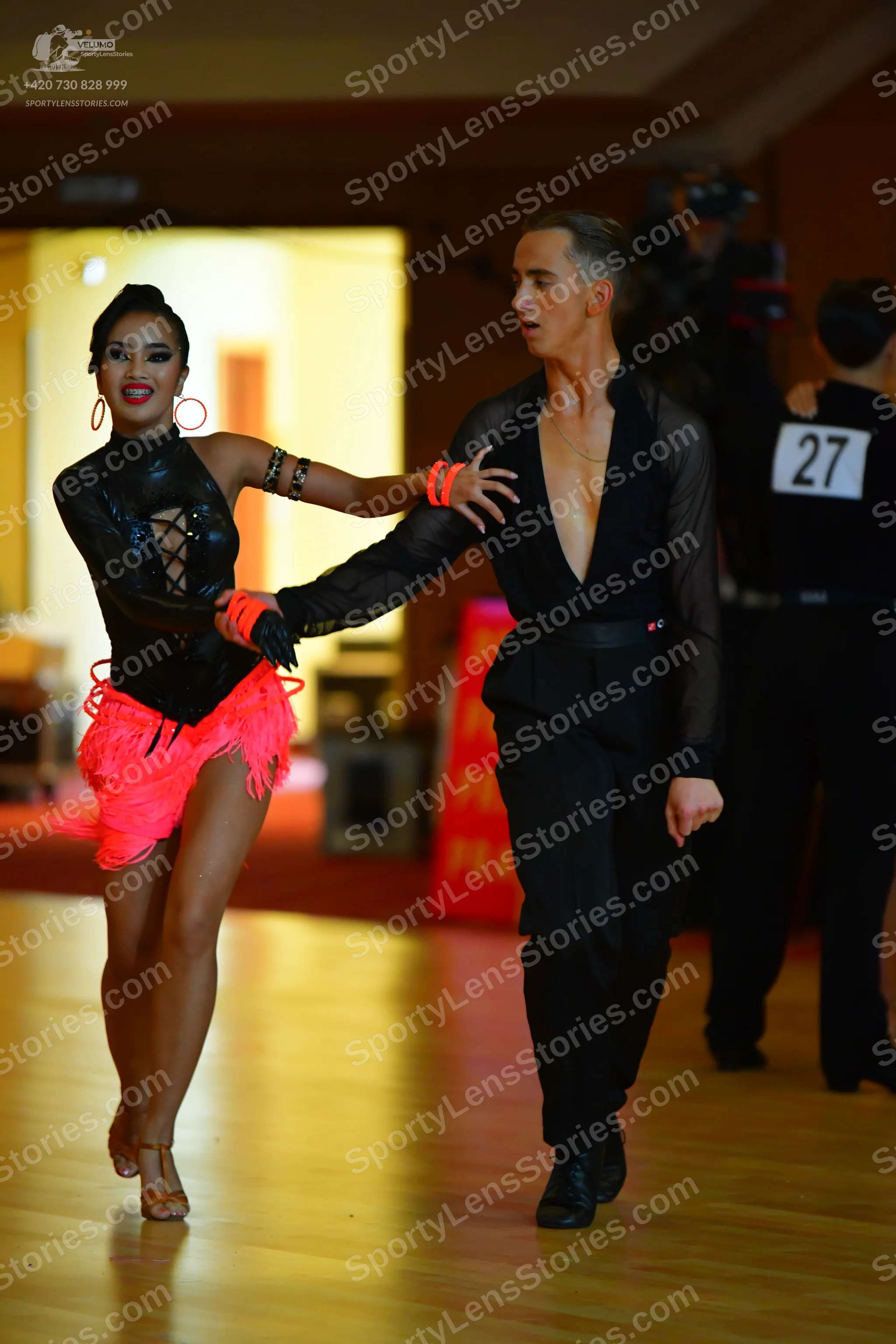 Dancesport competitor #27: Female dancer: black long-sleeved latin dress with a cutout bodice and neon pink