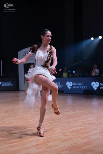 Dancesport competitor: Female dancer: white latin dress with leopard print pattern and white fringe