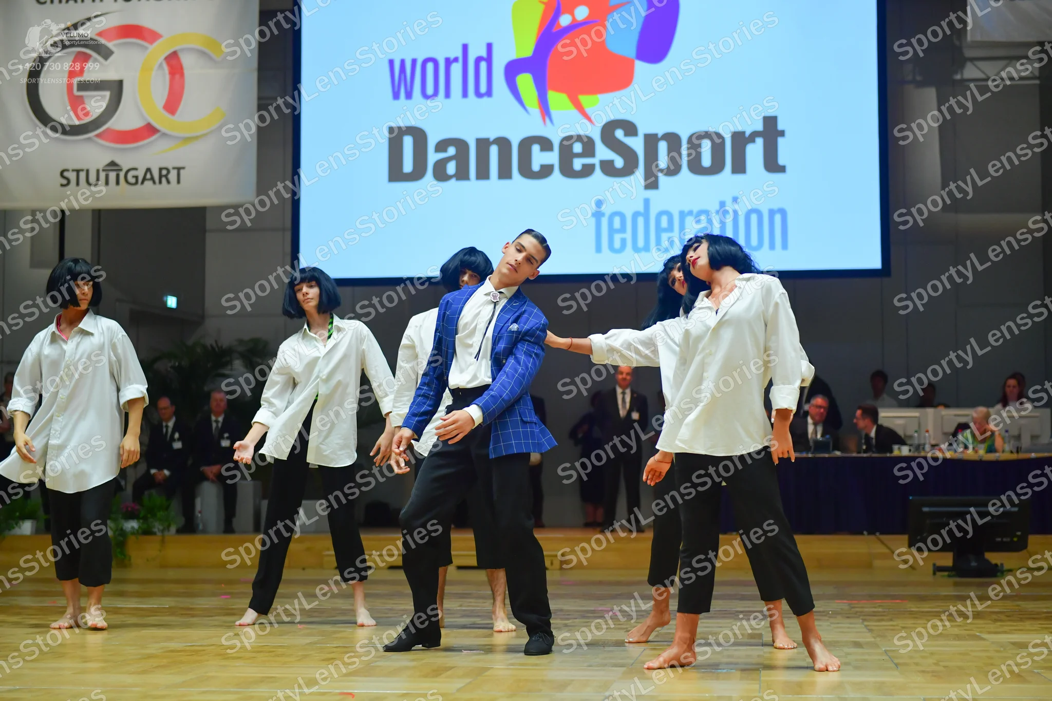 Dancesport competitor: Female dancers: white long-sleeved button-up shirts, black cropped trousers, and