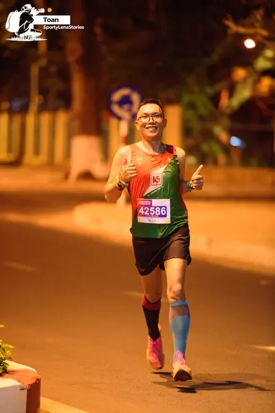 Marathon runner #42586: Runner 1: multicolored patterned tank top, black shorts, pink shoes, glasses, wa