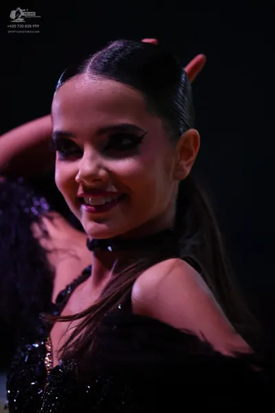 Dancesport competitor: Female dancer: black dance costume with sequins and textured/feathered details o