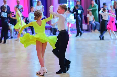Dancesport competitor #668, #11: Female dancer: neon yellow/lime green Latin dress with long sleeves and a flared