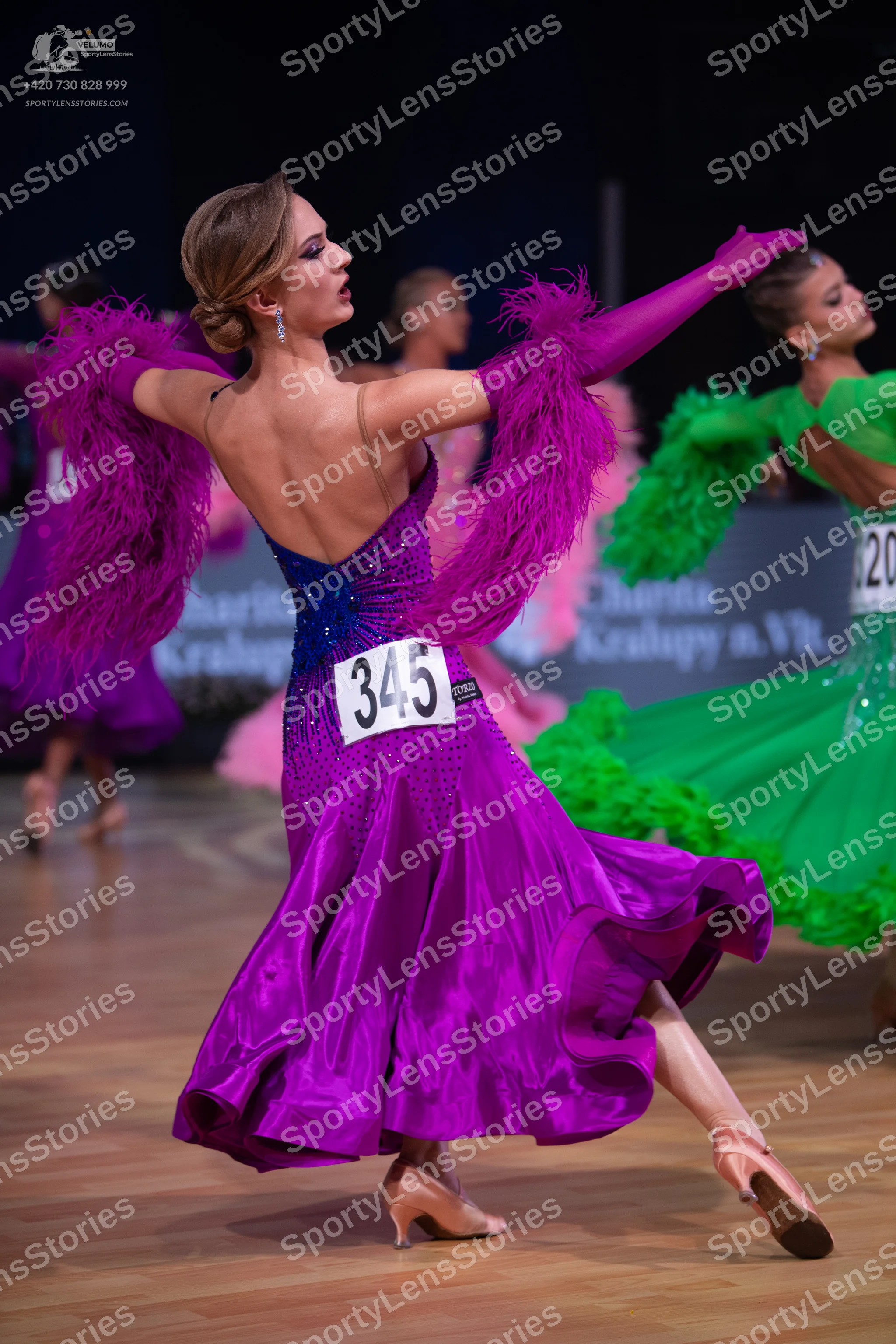 Dancesport competitor: Central female dancer: purple satin latin dress with a dark blue sequined bodice