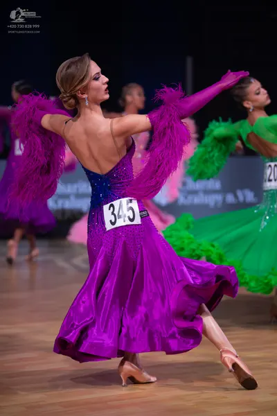 Dancesport competitor: Central female dancer: purple satin latin dress with a dark blue sequined bodice