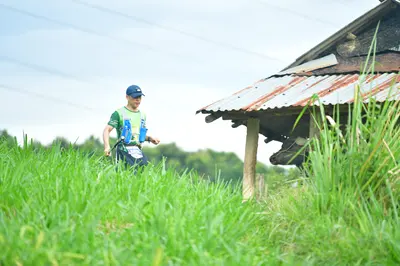 Marathon runner: Runner 1: green and white jersey, dark shorts, blue cap, and carrying two blue w