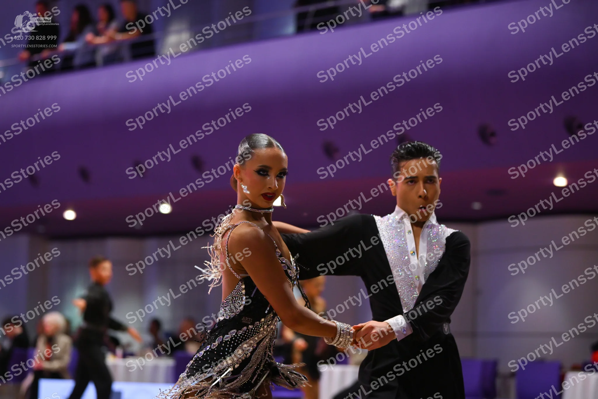 Dancesport competitor: Female dancer: dark grey or black Latin dress with heavy sequin and crystal embe