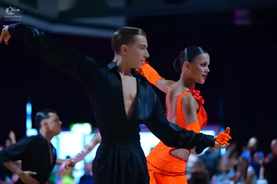 Dancesport competitor: Male dancer: black long-sleeved shirt with a deep V-neck