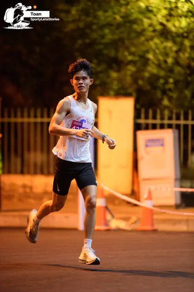 Marathon runner #423: Runner 1: white tank top, black shorts, white socks, grey running shoes, watch