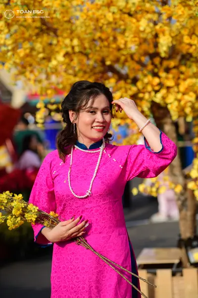 Dancesport competitor: Female dancer: pink long-sleeved Áo dài with a floral pattern and a pearl neckla