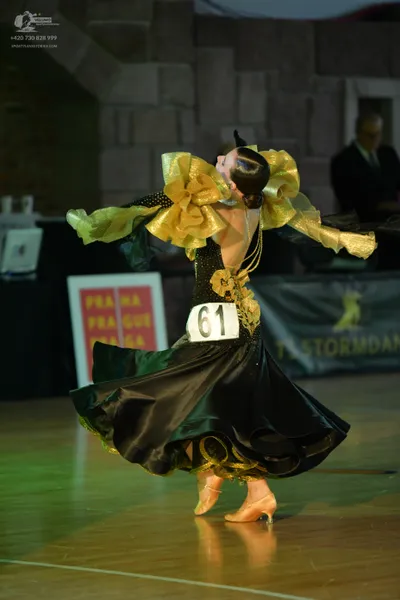 Dancesport competitor #61: Female dancer: black and gold ballroom gown with a large, voluminous black skirt