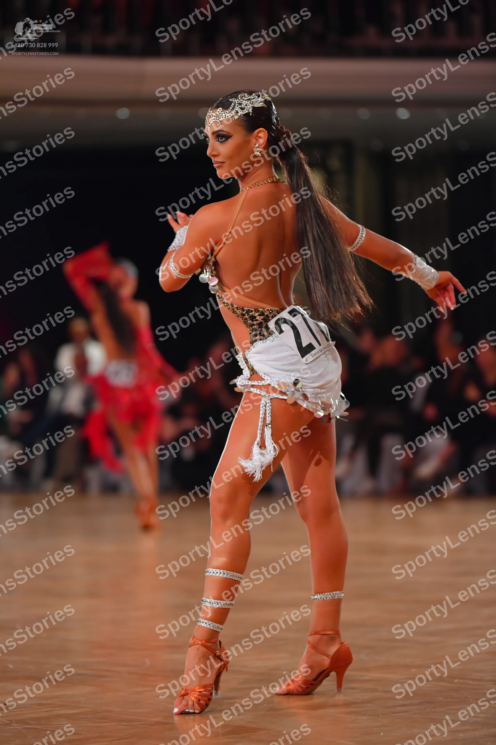 Dancesport competitor #27: Female dancer (foreground): leopard print and white latin bodysuit with white fr