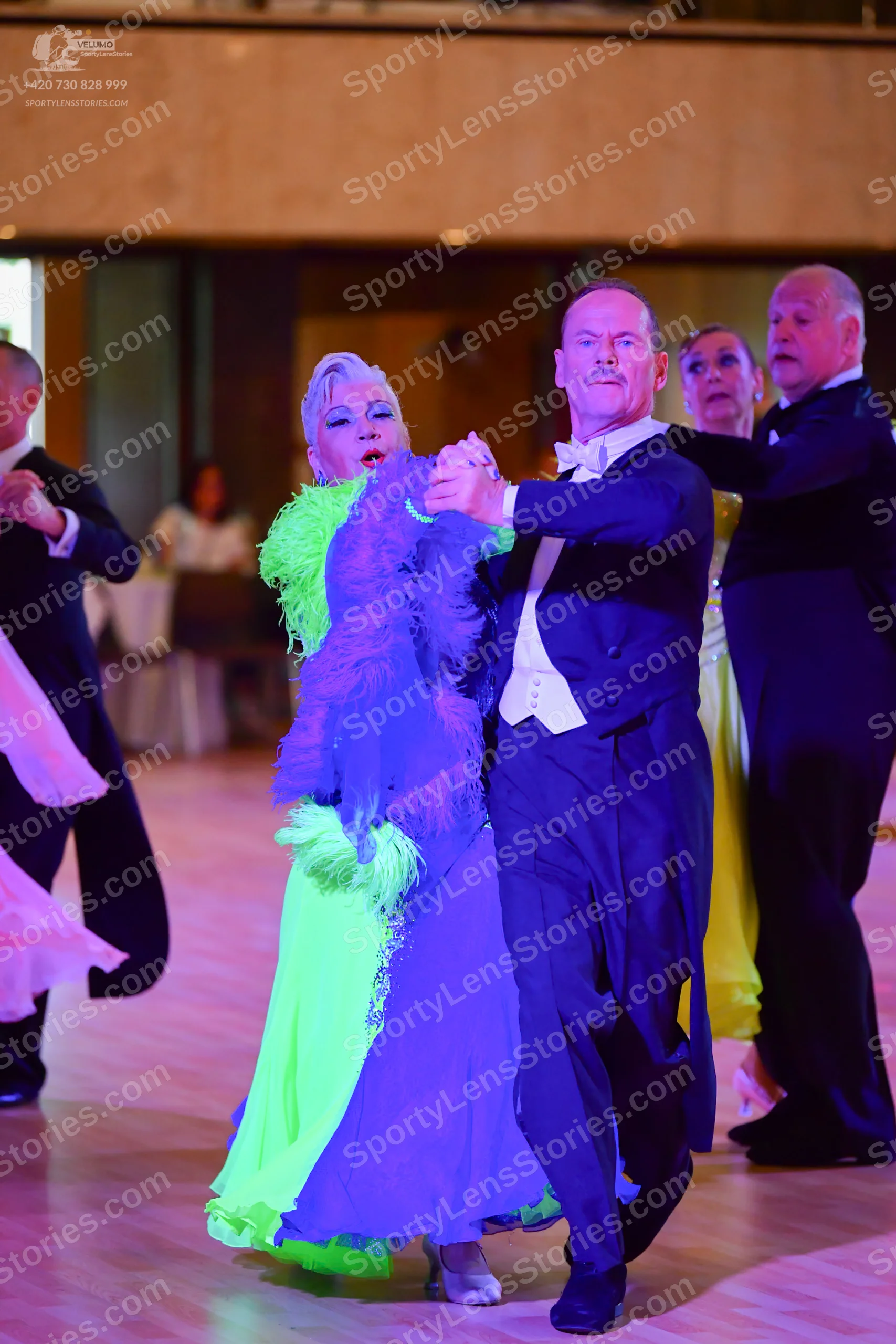 Dancesport competitor: Okay, here's a breakdown of the dancers' costumes in the photo, formatted as you