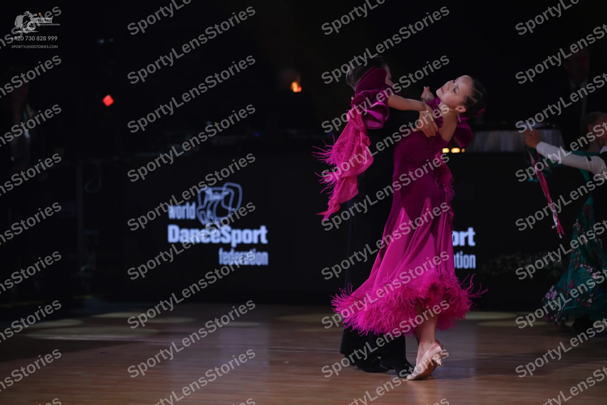 Dancesport competitor: Female dancer: bright pink Latin dress with layers of fringe