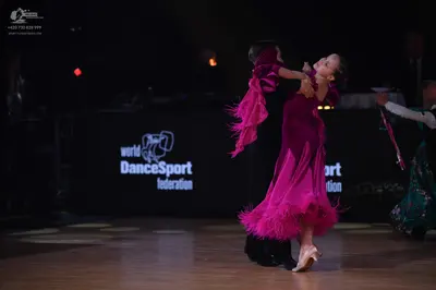 Dancesport competitor: Female dancer: bright pink Latin dress with layers of fringe