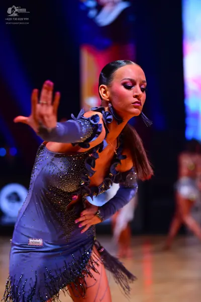 Dancesport competitor: Female dancer: blue latin dress with ruffles, sequins, and fringe