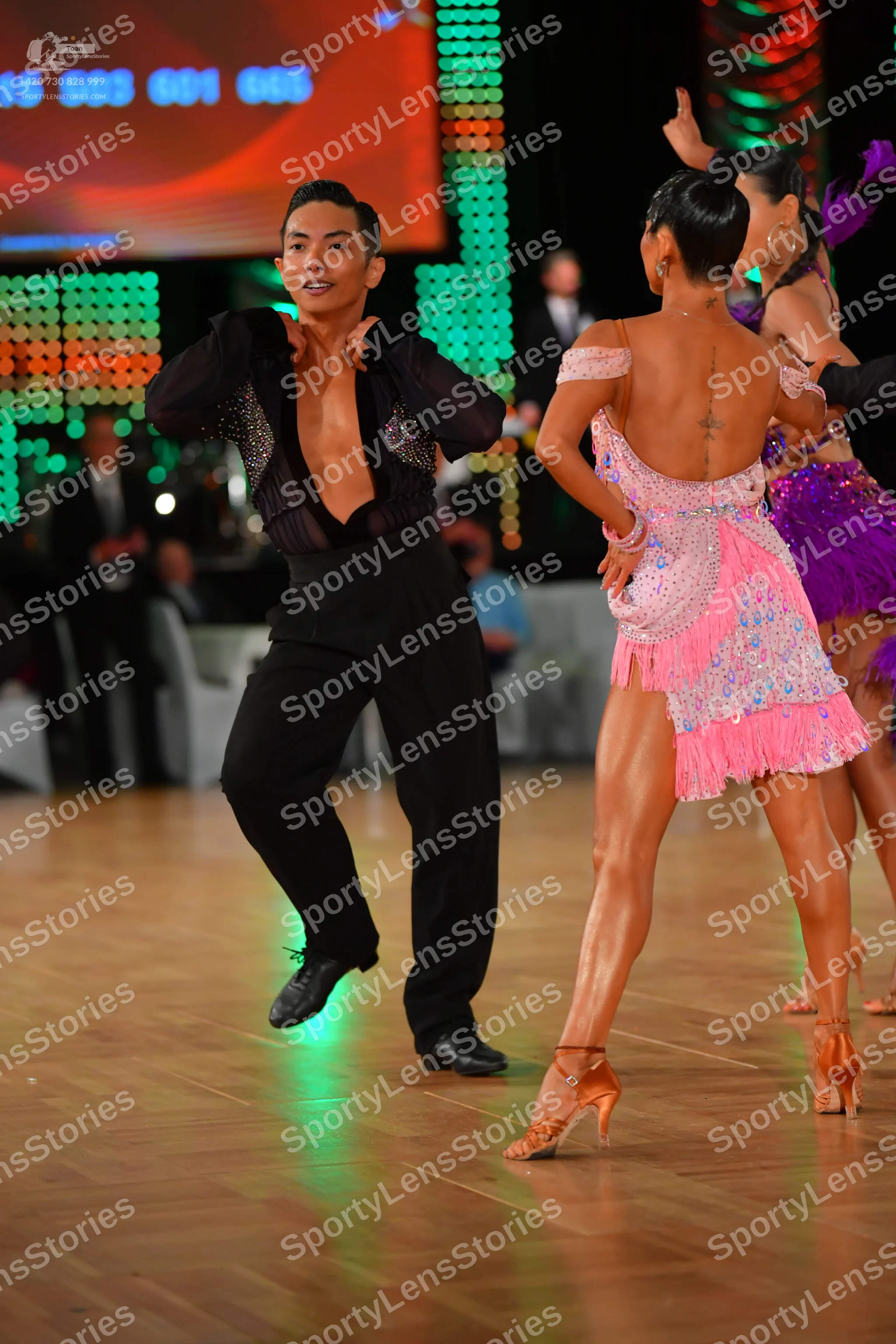 Dancesport competitor: Male dancer: black long-sleeved shirt with sequins on the front, black trousers,