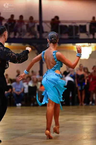 Dancesport competitor: Male dancer: black long-sleeved shirt with lace-patterned sleeves and black trou