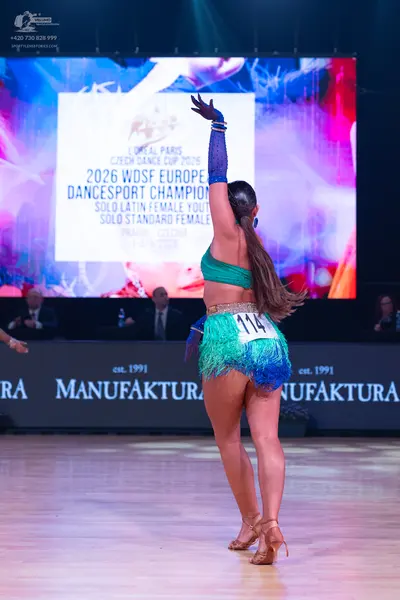 Dancesport competitor: Female dancer: teal Latin dance costume featuring a crop top and a fringe skirt 