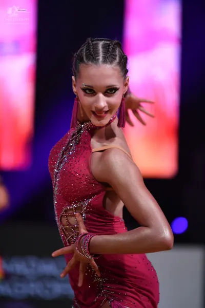 Dancesport competitor: Female dancer: magenta Latin dress with crystal embellishments and cutouts