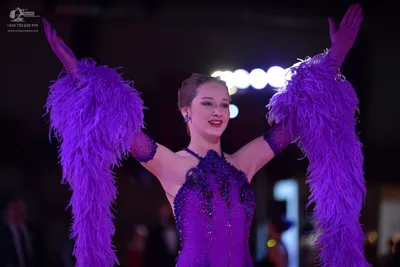 Dancesport competitor: Female dancer: purple/lavender Latin-style dress with voluminous feather sleeves