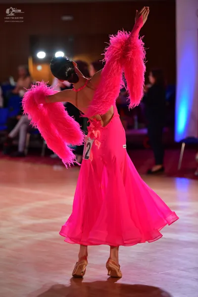 Dancesport competitor #12: Female dancer: bright pink Latin dress with large, fluffy pink feather-like slee