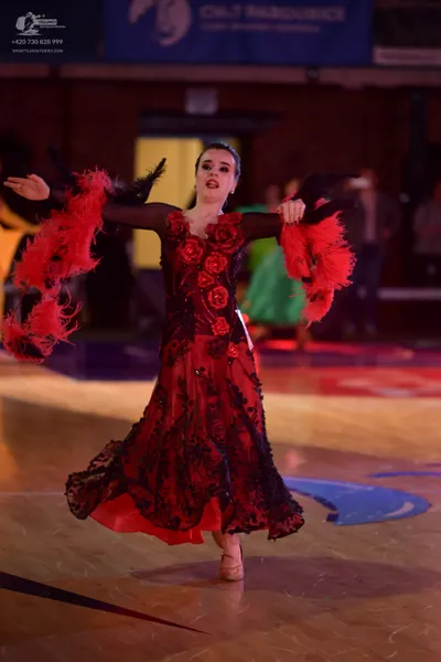 Dancesport competitor: Female dancer: red and black ballroom dress with a black lace overlay, red flora