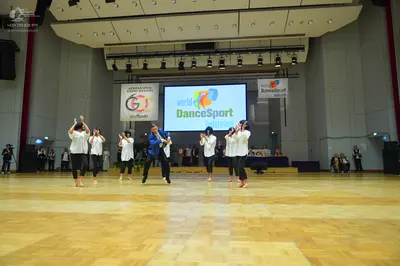 Dancesport competitor: All dancers are wearing matching costumes consisting of long-sleeved white shirt