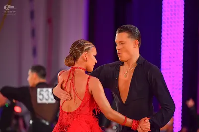 Dancesport competitor #535: Male dancer: black long-sleeved shirt, unbuttoned, with a gold necklace