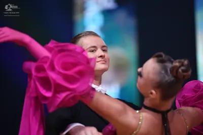 Dancesport competitor: Male dancer: black shirt or suit with a white collar visible