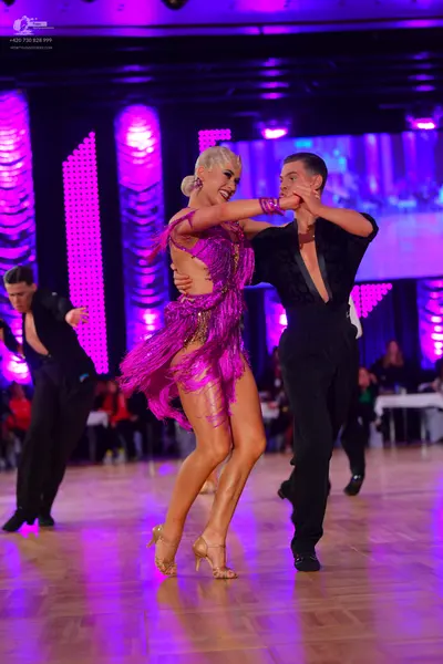 Dancesport competitor: Male dancer (left): black shirt and black trousers