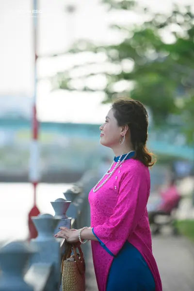 Dancesport competitor: Female dancer: magenta pink top with lace-like texture and a blue skirt, accesso