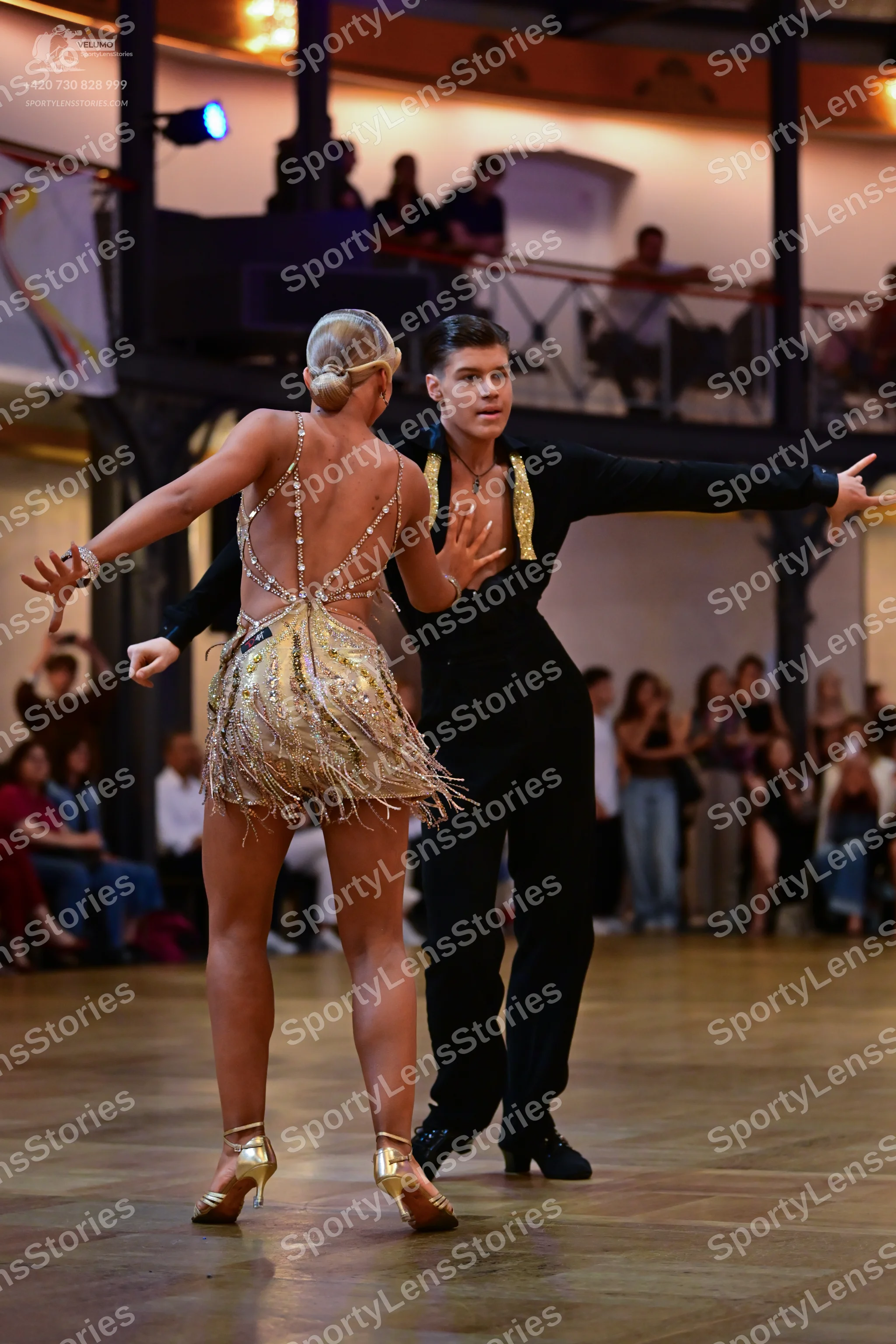 Dancesport competitor: Male dancer: black Latin dance outfit with gold-colored accents on the collar/la