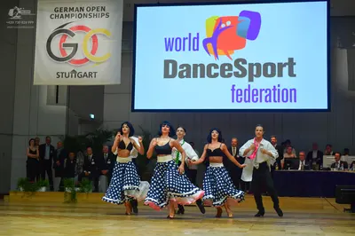 Dancesport competitor: Three female dancers: black bra-style tops and blue and white polka-dotted skirt