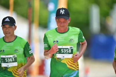 Marathon runner #5361, #5358: Runner 1: green jersey, black cap