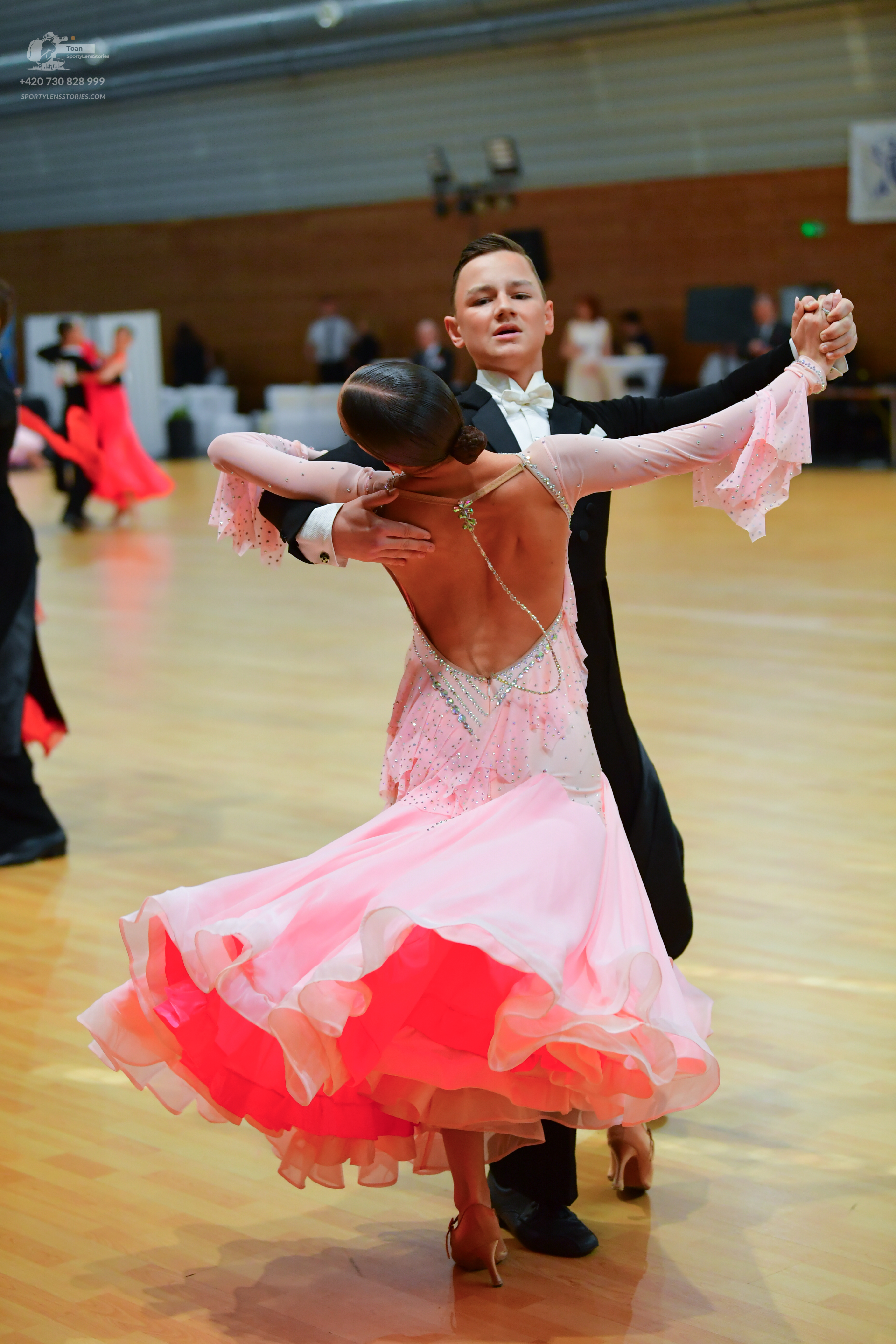 Dancesport competitor: Here's a breakdown of the dancers' costumes in the photo, formatted as requested
