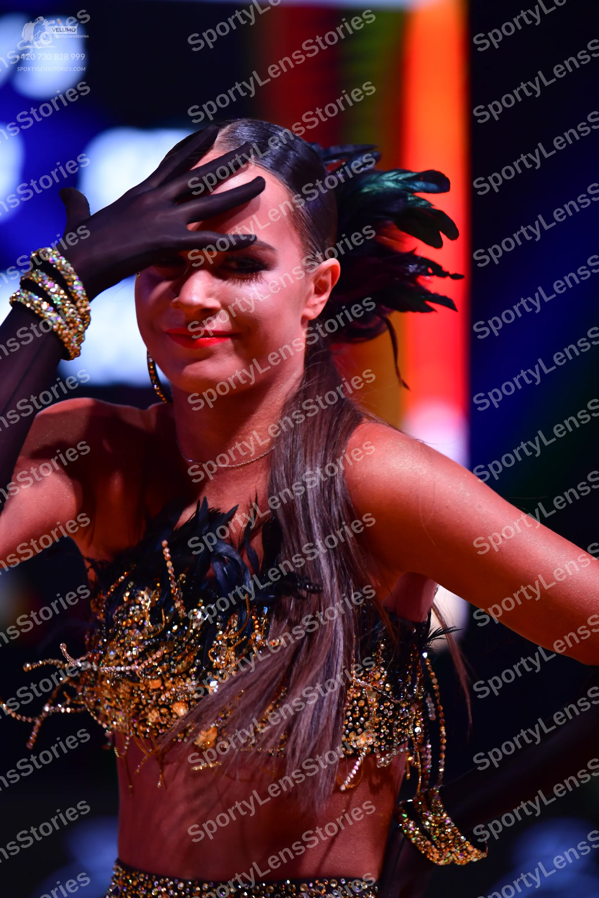 Dancesport competitor: Female dancer: black two-piece latin costume featuring a crop top and matching b