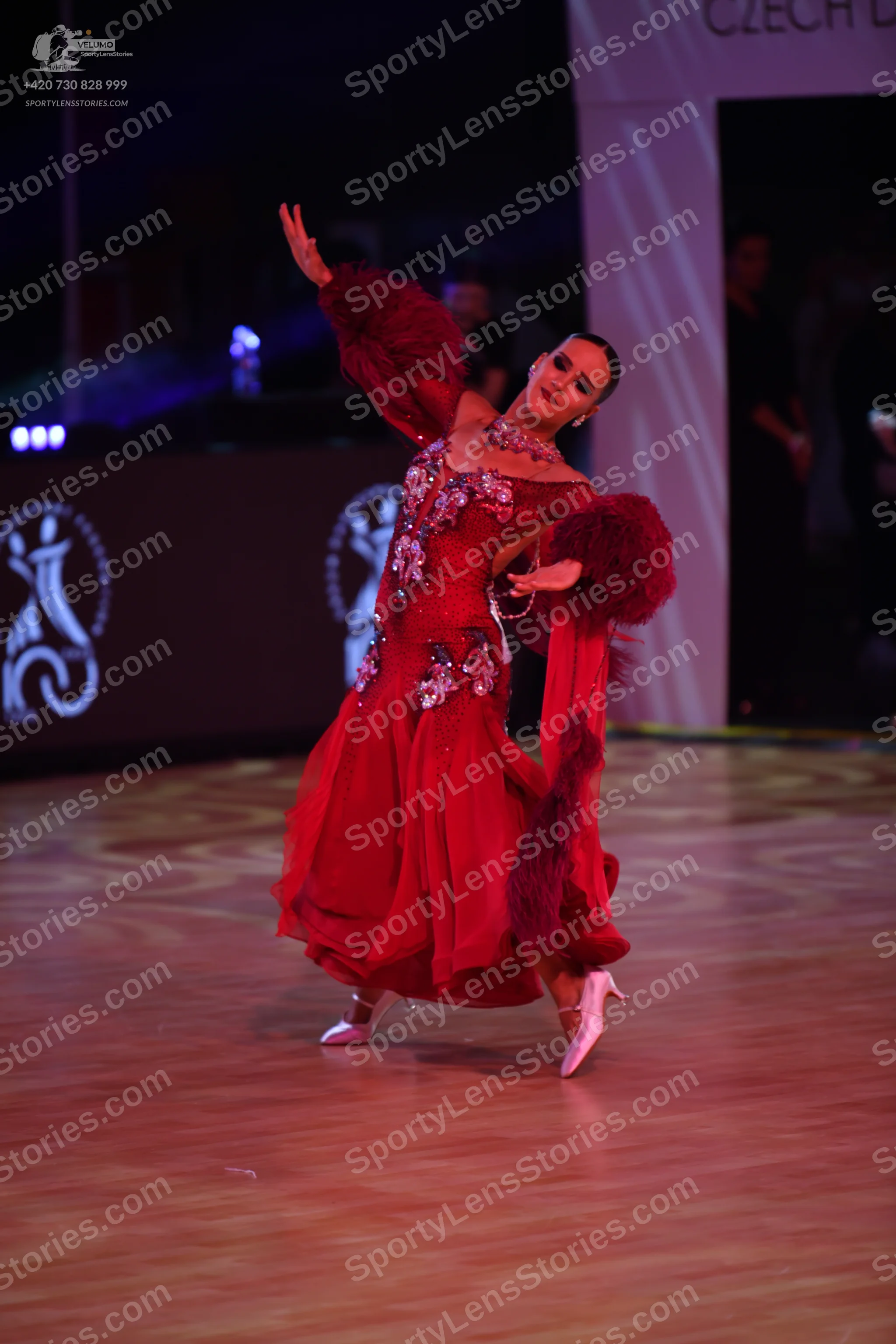 Dancesport competitor: Female dancer: red ballroom dress with long, voluminous sleeves and sequin/beade