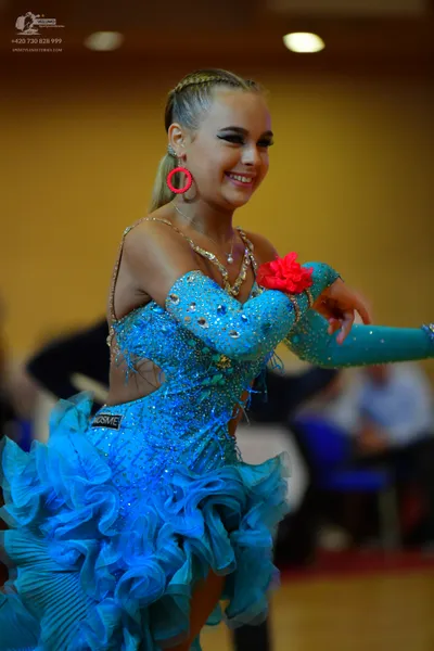 Dancesport competitor: Female dancer: light blue Latin dance dress with sequins and large ruffles, pair