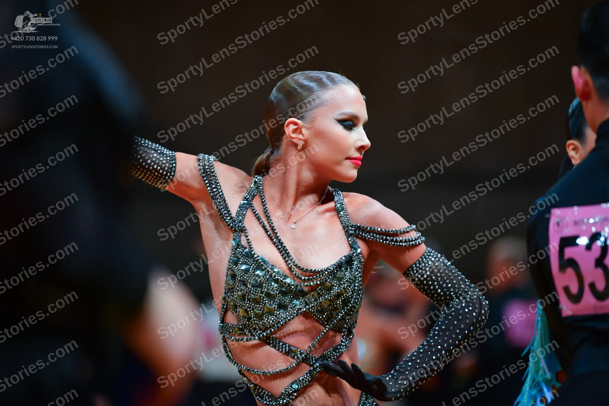 Dancesport competitor: Female dancer: nude-colored Latin dance costume heavily embellished with silver