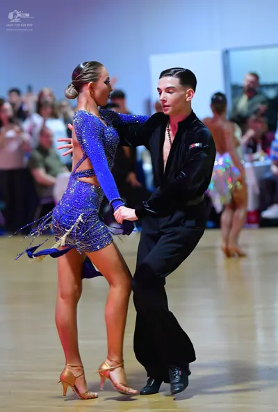 Dancesport competitor: Female dancer: royal blue latin dance dress with sequins, long sleeves, waist cu