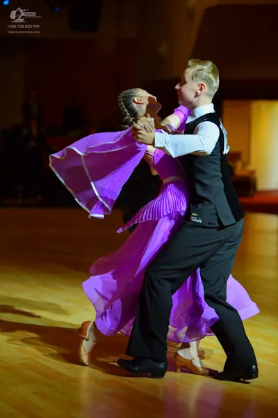 Dancesport competitor: Male dancer: black waistcoat over a white long-sleeved shirt and black trousers