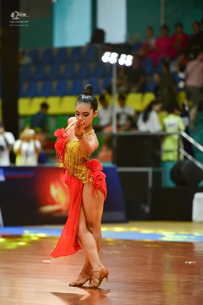 Dancesport competitor: ** Female: Red latin dress with fringe