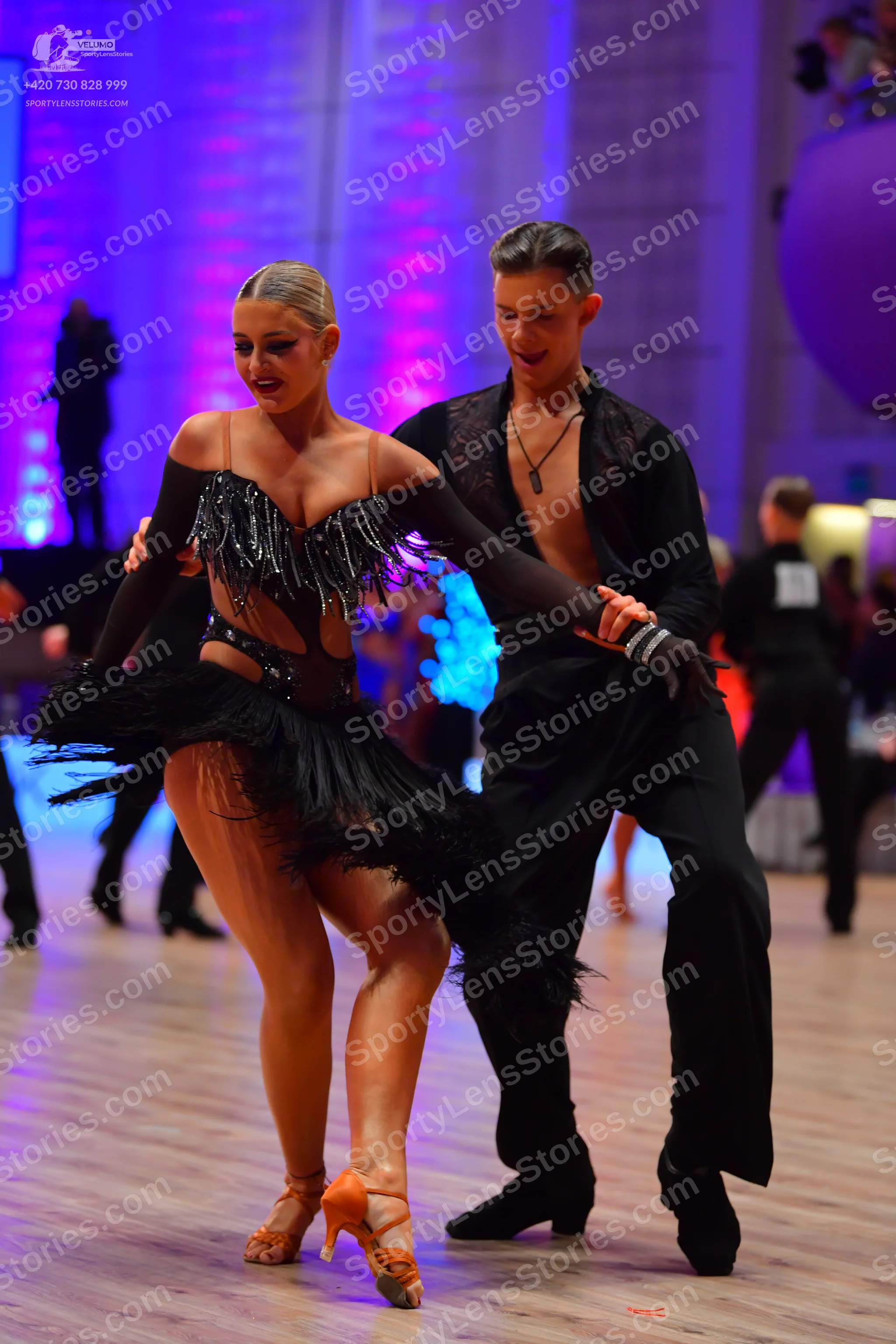 Dancesport competitor: Male dancer: black long-sleeved shirt, unbuttoned at the chest, and black trouse