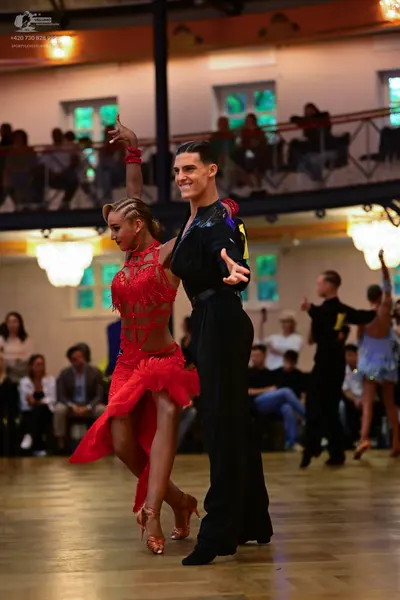 Dancesport competitor: Female dancer: red latin dress with lace/mesh bodice and ruffled skirt