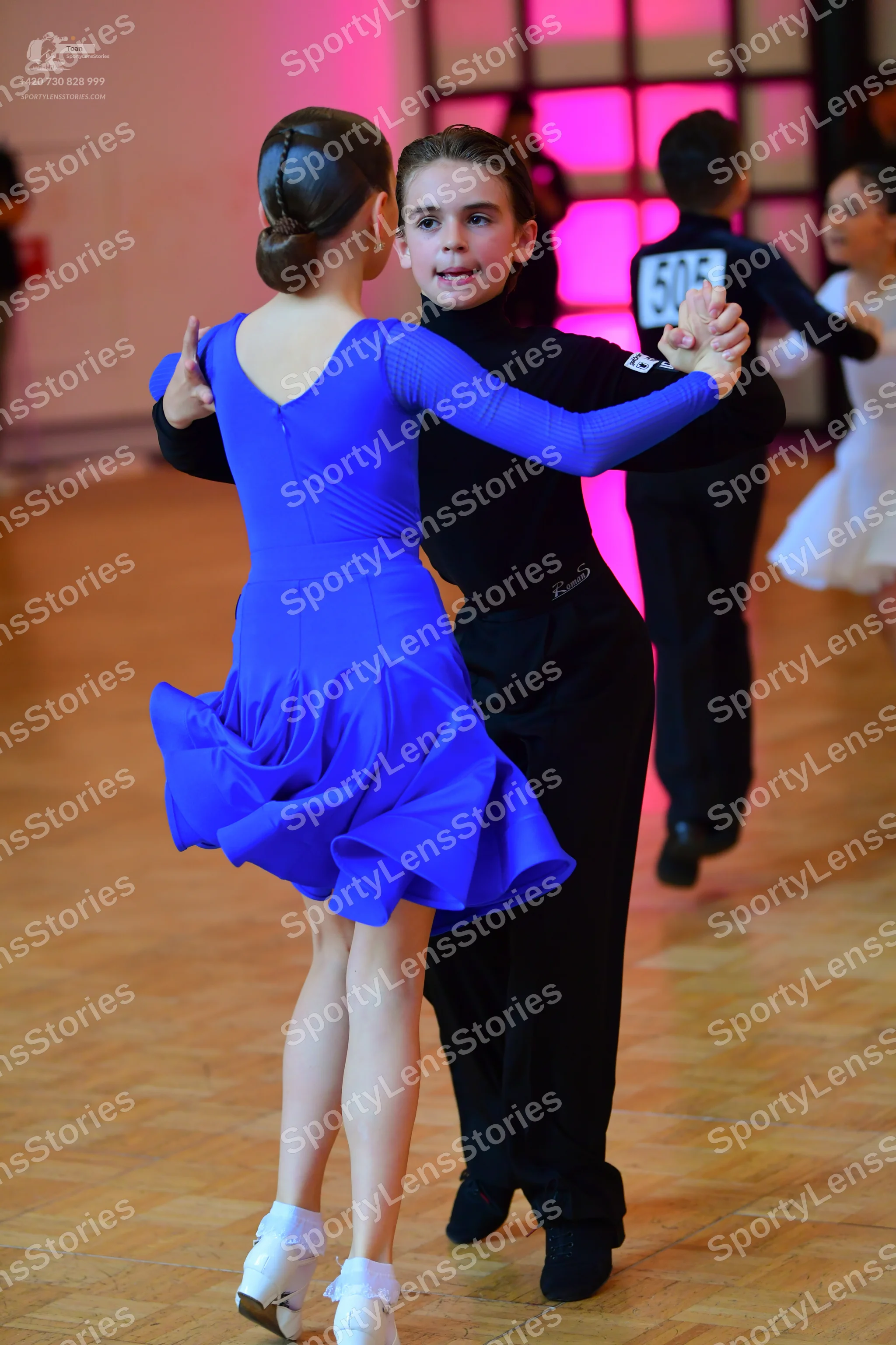 Dancesport competitor #505: Female dancer (foreground): blue long-sleeved dance dress with a flared skirt