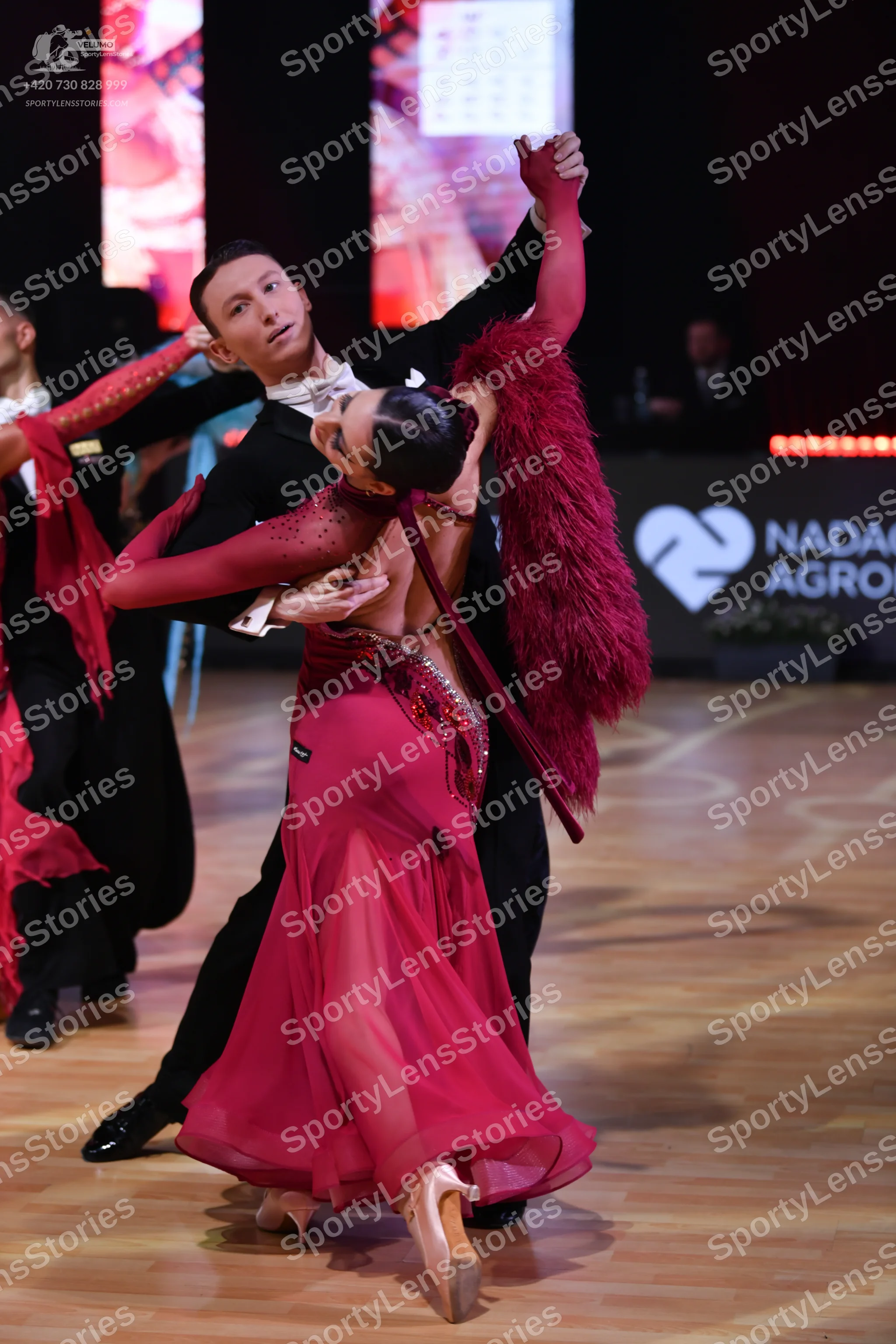 Dancesport competitor: Female dancer: magenta long-sleeved Latin dress with sequin embellishments and a
