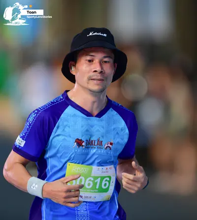 Marathon runner #0616: Runner 1: blue and purple jersey, black bucket hat, white wristband