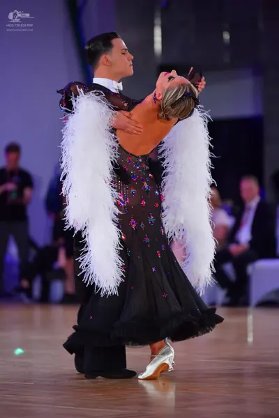 Dancesport competitor: Male dancer: black suit with a white shirt and white bowtie