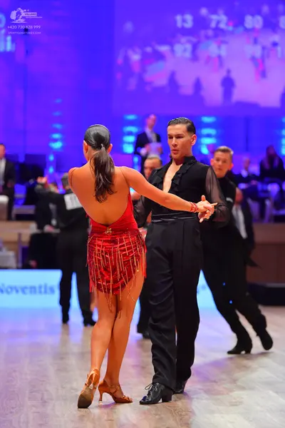 Dancesport competitor: Female dancer: red backless Latin dress with sequins and long fringe